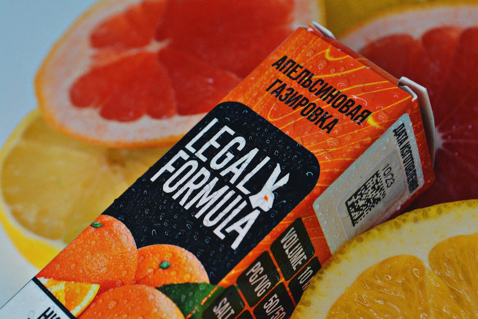 Жидкость Лигал Формула Апельсиновая Газировка лежащая на дольках грейпфрута и апельсина